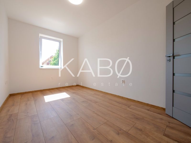 Ein Zimmer mit Holzboden in einem Einfamilienhaus ohne Möbel.