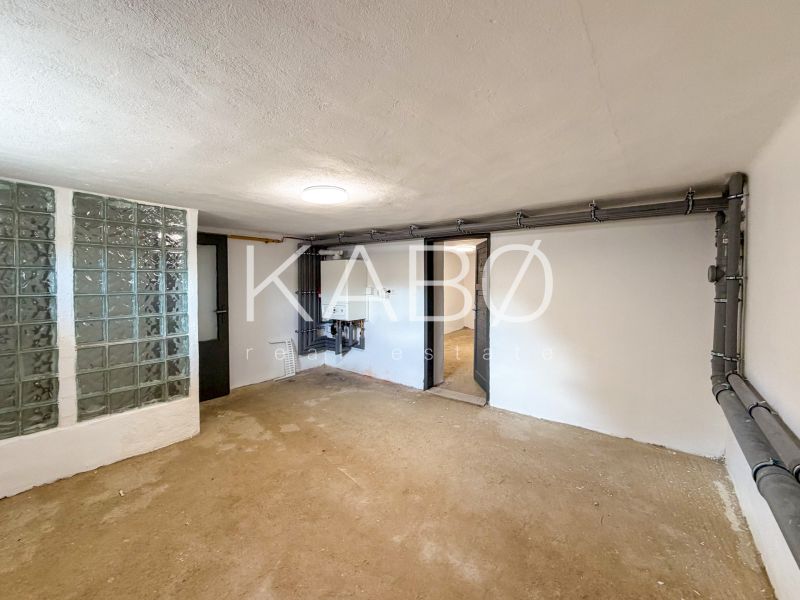 Ein Raum in einem Einfamilienhaus mit einer Glasbausteinwand und Installationen an der Wand.