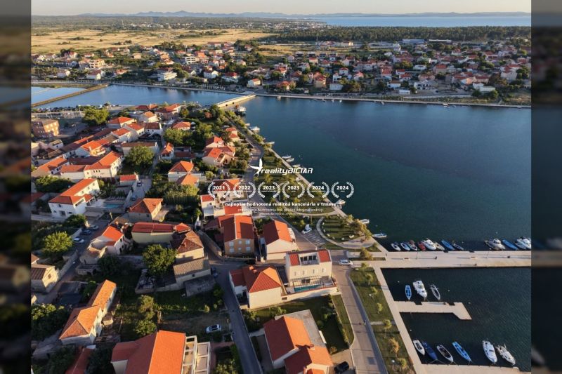 Luftaufnahme des Küstengebiets der Stadt Nin mit den Dächern von Villen und dem Hafen.