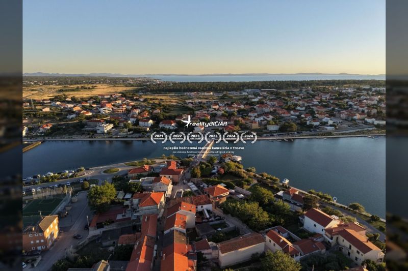 Luftaufnahme der Stadt Nin mit Villen entlang der Küste und Meerblick.