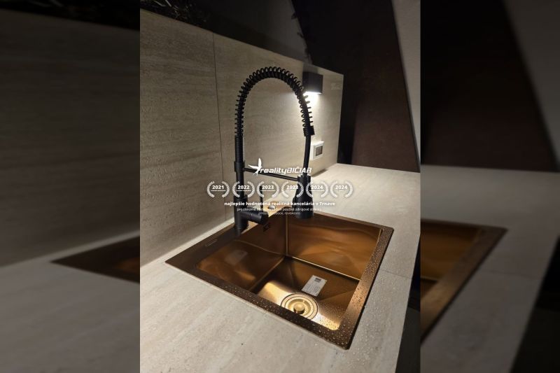 Küchenarmatur mit flexiblem Wasserhahn und goldenem Küchenspülbecken in einer Villa.