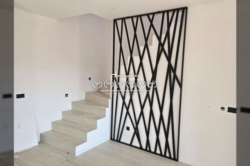 Treppe mit schwarzem dekorativem Geländer und Boden mit Holzdekor in der Villa.