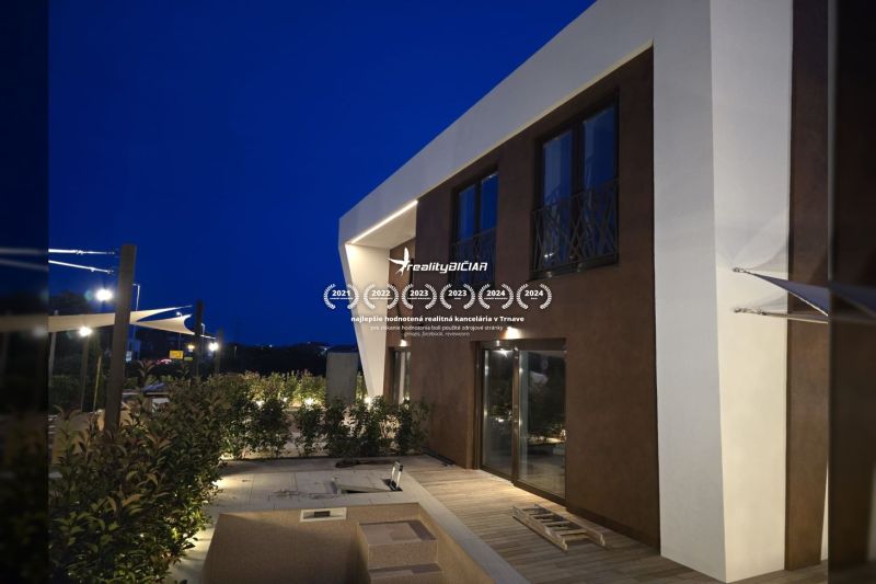 Eine Villa in der Straße Nin in Nin mit moderner Architektur und einer Terrasse am Abend.