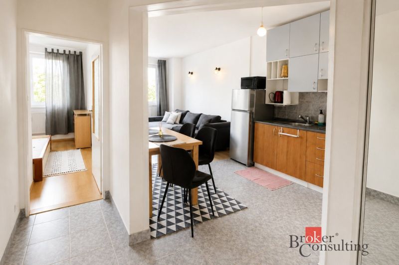 Innenraum einer 2-Zimmer-Wohnung mit Küche, Wohnzimmer und Holzboden.