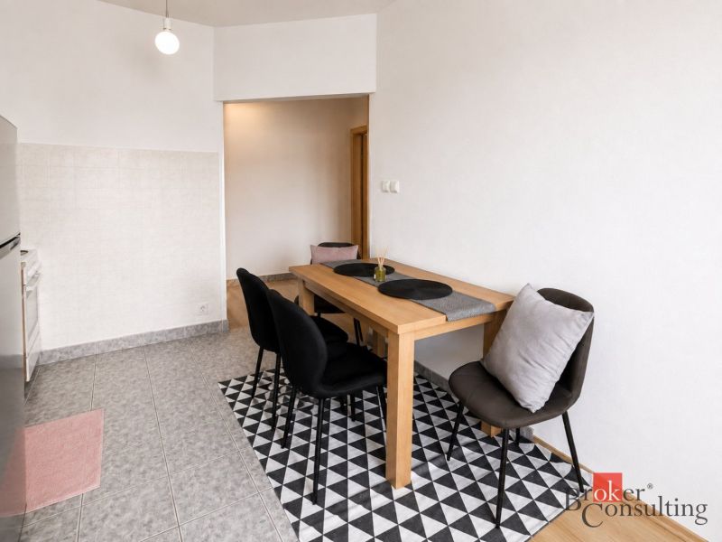 Essbereich in einer 2-Zimmer-Wohnung mit schwarzen Stühlen und einem Holztisch.
