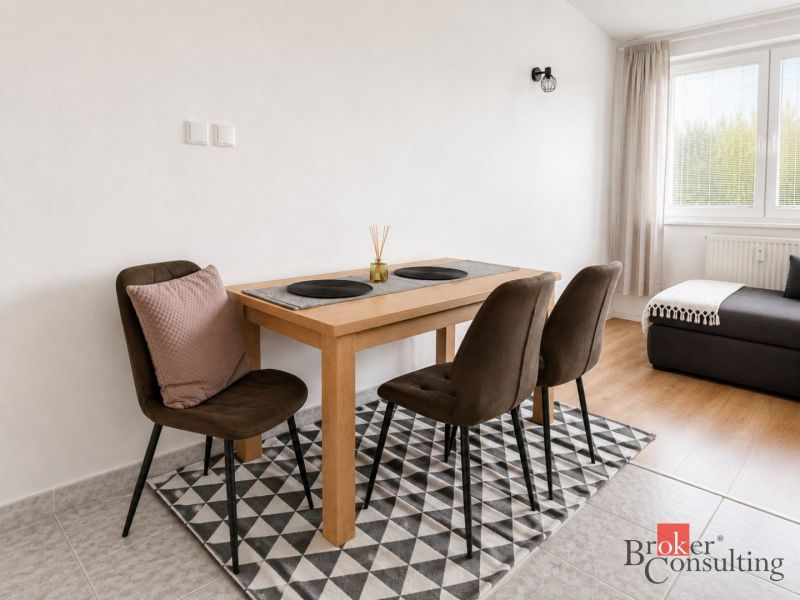 Essbereich mit Tisch und Stühlen in einer 2-Zimmer-Wohnung, mit einem Boden in Holzoptik.