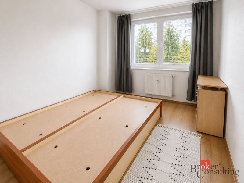 Helles Schlafzimmer in einer 2-Zimmer-Wohnung mit Bett und Holzboden.