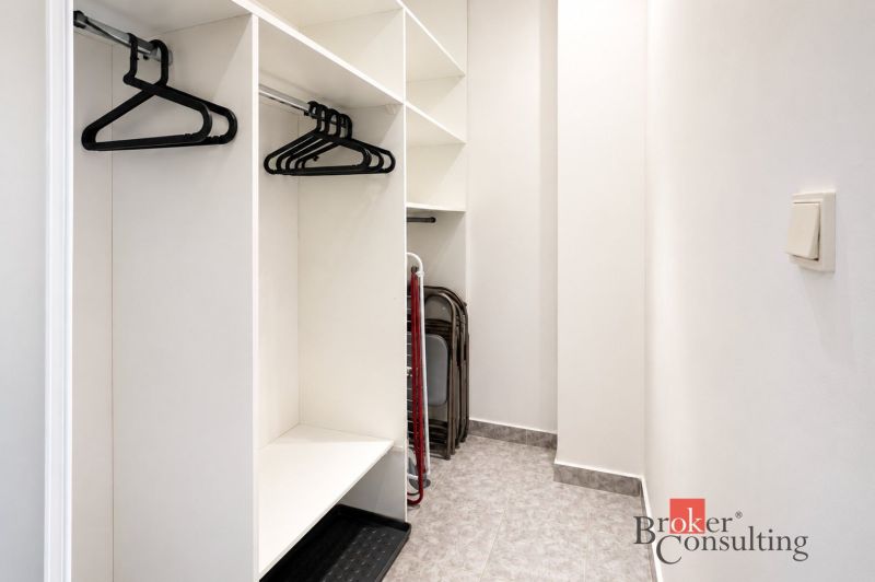 Stauraum mit Kleiderbügeln in einer 2-Zimmer-Wohnung und einem Boden mit Dekor.