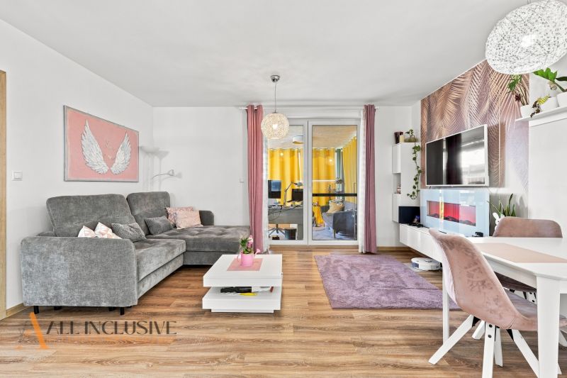 Wohnzimmer in einem Einfamilienhaus mit einem bequemen Sofa und einem Boden in Holzoptik.