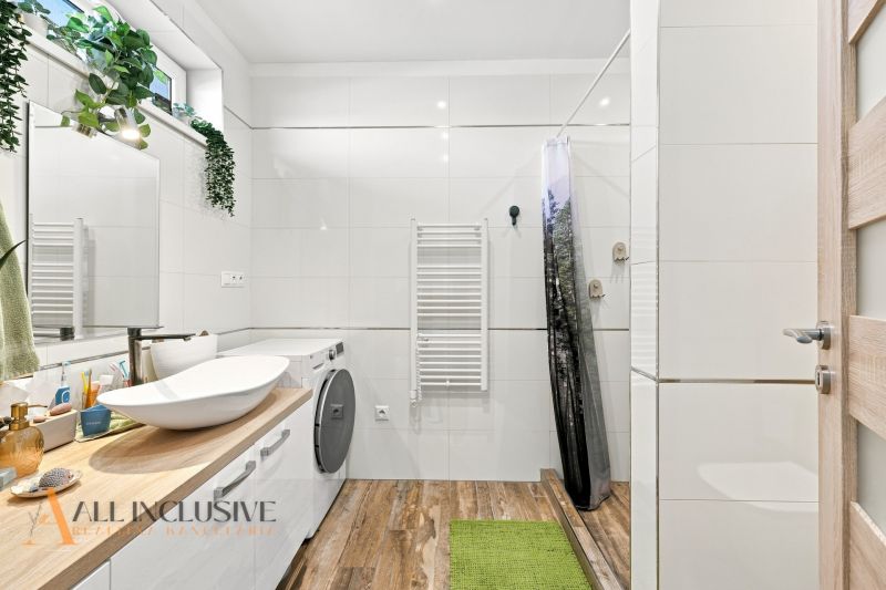 Badezimmer im Einfamilienhaus mit Holzboden-Dekor und Waschmaschine.