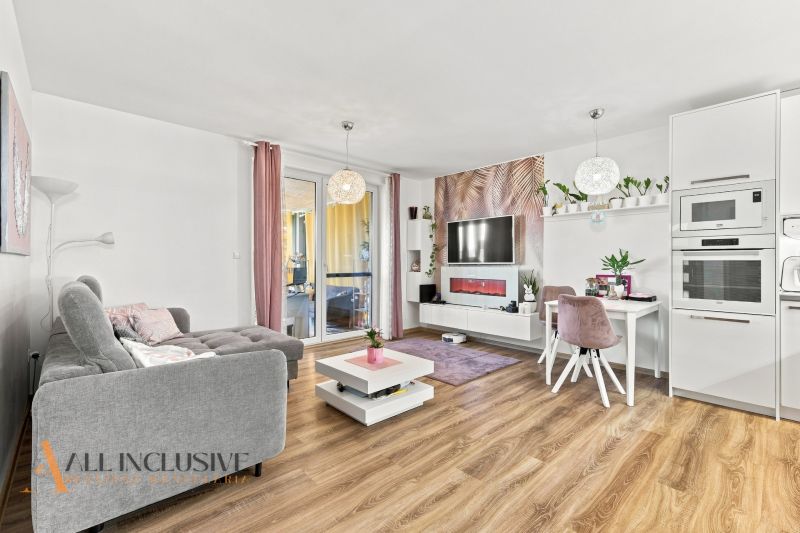 Wohnzimmer mit bequemer Couch, Fernseher, Esstisch und Holzboden in einem Einfamilienhaus.