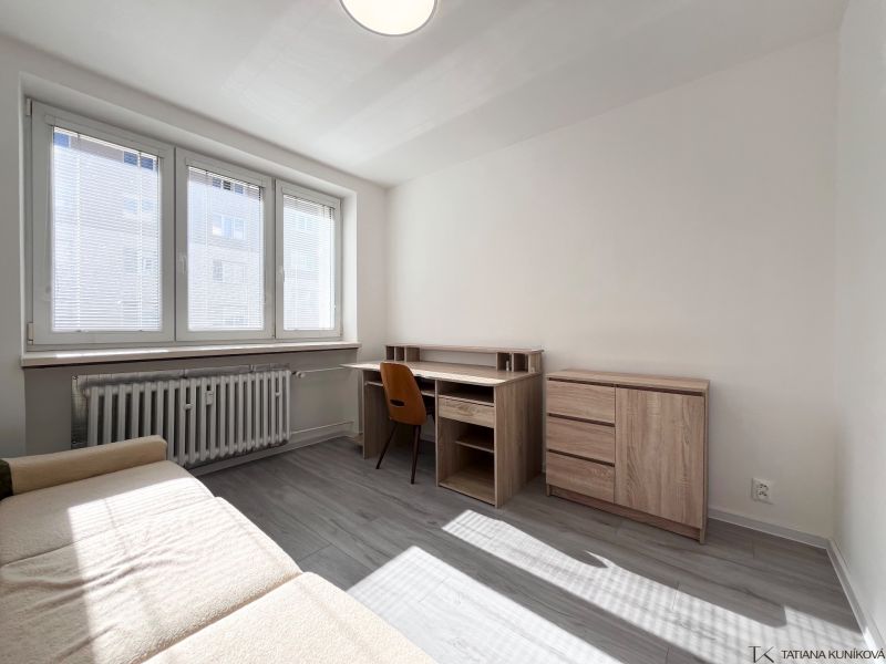 Wohnzimmer mit Schreibtisch und Sofa, Holzboden in einer 3-Zimmer-Wohnung.