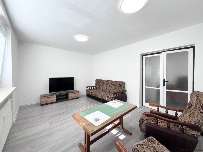 Wohnzimmer in einer 3-Zimmer-Wohnung mit Holzboden und Einrichtung.