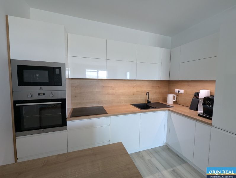 Küche in einer 2-Zimmer-Wohnung mit Holzboden und modernen Geräten.