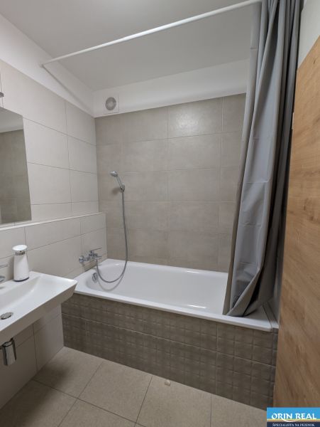 Ein Badezimmer in hellen Tönen mit Badewanne und Duschkabine, ideal für eine 2-Zimmer-Wohnung.