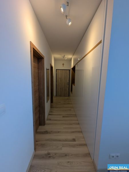 Flur in einer 2-Zimmer-Wohnung mit einem Holzboden und weißen Wänden.