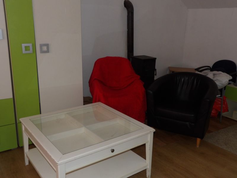 Wohnzimmer in einer Zweizimmerwohnung mit Sesseln und einem Tisch auf einem Boden mit Holzdekor.