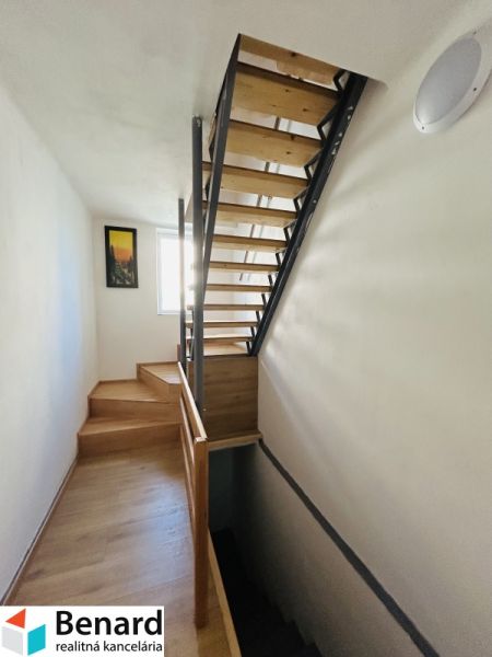 Eine Treppe mit Holzdekor in einem Einfamilienhaus mit hellem Interieur und einem Bild an der Wand.
