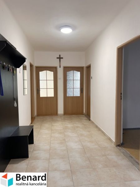 Flur in einem Einfamilienhaus mit Fliesen, Holztüren und Garderobe.