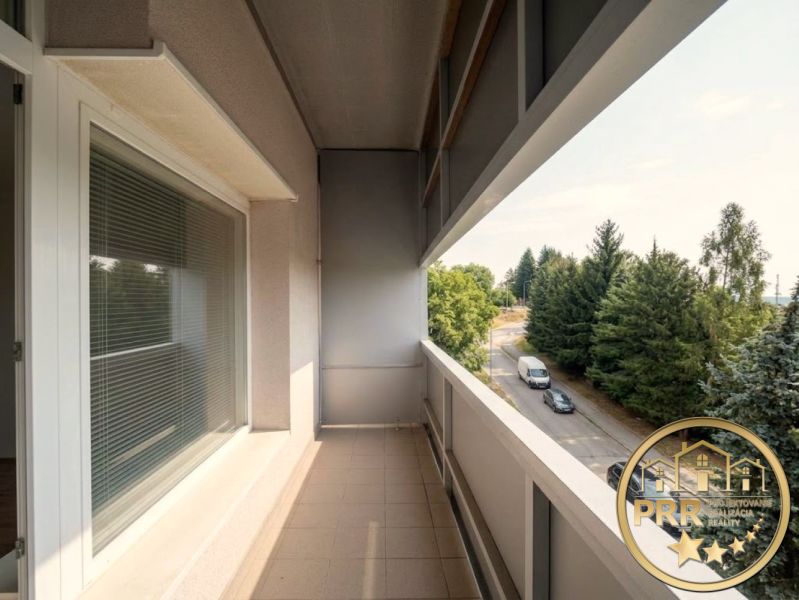 Der Balkon einer 2-Zimmer-Wohnung in Bánovce nad Bebravou mit Blick auf die Straße und Bäume.