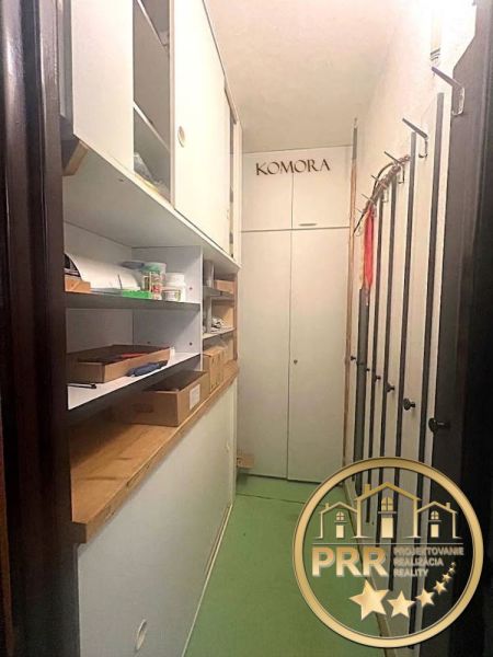 Stauraum in einer 2-Zimmer-Wohnung mit Regalen und Boxen, grüne Böden.