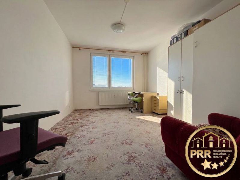 Ein Zimmer mit Teppich und Möbeln in einer 2-Zimmer-Wohnung, helles Interieur.