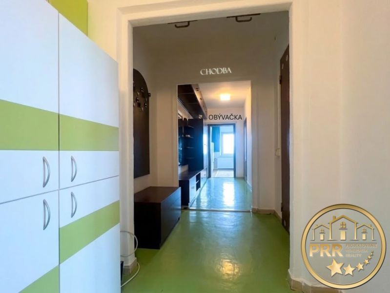 Der Flur in der 2-Zimmer-Wohnung mit grünem Boden und Möbeln mit weiß-grünen Elementen.