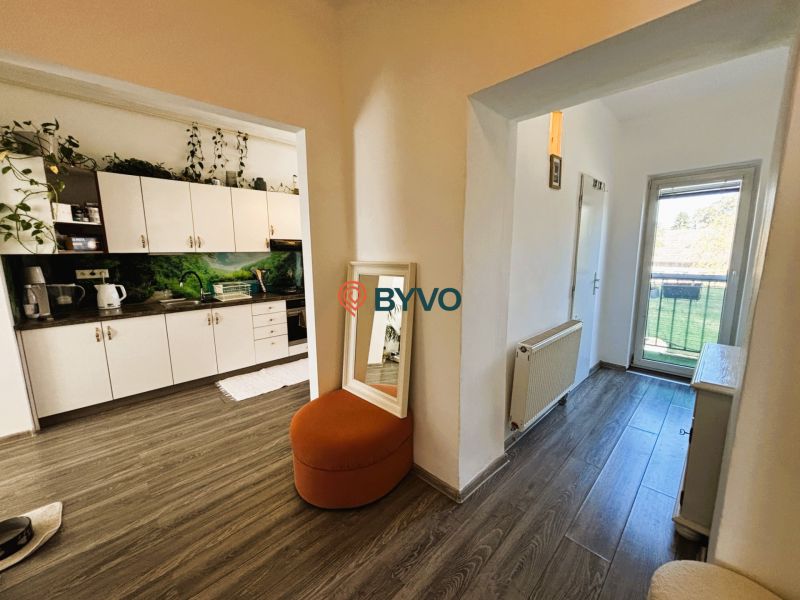 Innenraum mit Küchenzeile, Boden in Holzoptik und Balkontüren in einer 2-Zimmer-Wohnung.