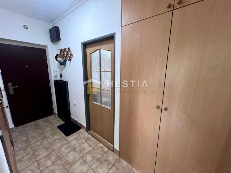 Flur mit Keramikfliesen in einer 2-Zimmer-Wohnung, eingebaute Schränke und Garderobe.