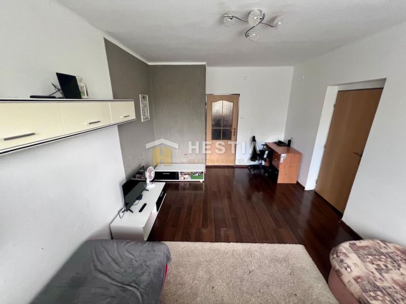 Wohnzimmer in einer Zweizimmerwohnung mit Holzboden und Möbeln.