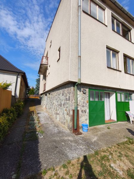 Ein Einfamilienhaus in Jelenec mit Steinverkleidung und grünen Türen.