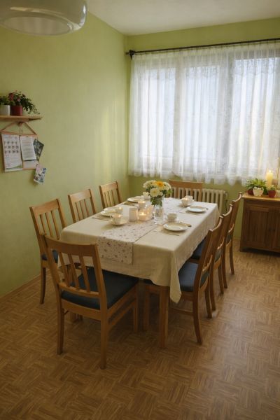 Esszimmer in einem Einfamilienhaus mit gedecktem Tisch und Boden in Holzoptik.