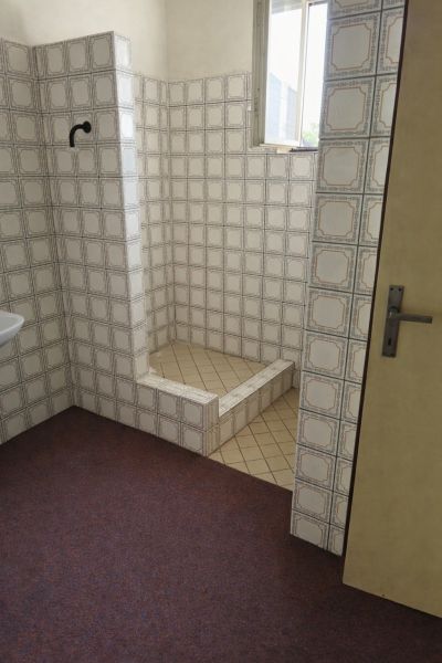 Badezimmer in einem Einfamilienhaus mit Retro-Fliesen und einer Duschkabine.