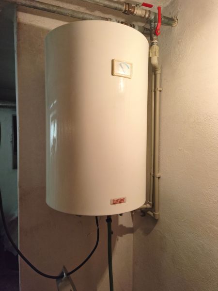 Ein Warmwasserspeicher an der Wand in einem Einfamilienhaus mit sehr einfachen Ventilen.
