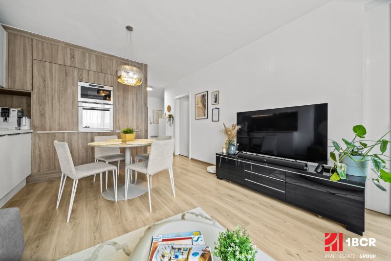 Wohnzimmer und Küche in einer 2-Zimmer-Wohnung mit Holzboden.
