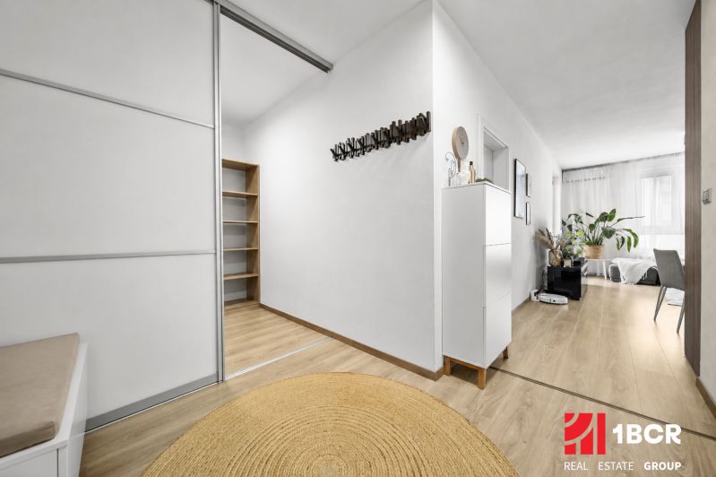 Innenraum einer 2-Zimmer-Wohnung mit Holzboden, Pflanzen und praktischen Möbeln.