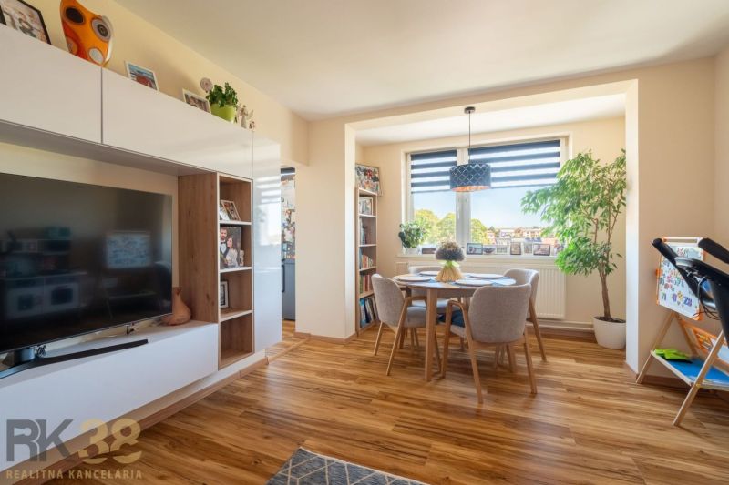 Wohnzimmer in einer 3-Zimmer-Wohnung mit Holzdekorboden und Essecke.