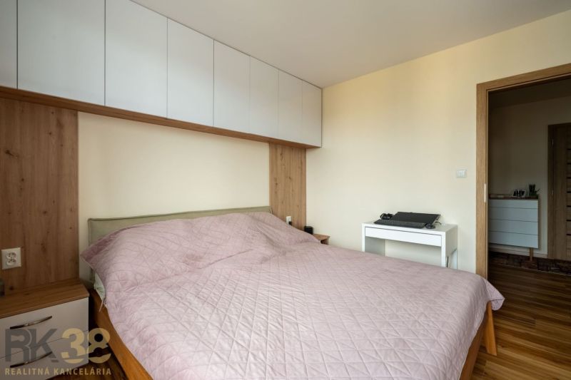 Schlafzimmer mit Bett, Schränken und Holzboden in einer 3-Zimmer-Wohnung.