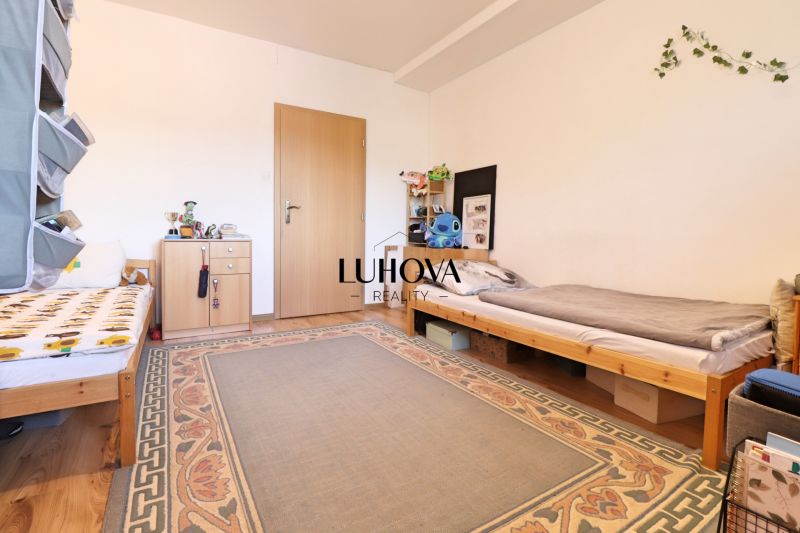 Kinderzimmer in einer 2-Zimmer-Wohnung mit zwei Betten und einem Teppich auf dem Boden mit Holzdekor.