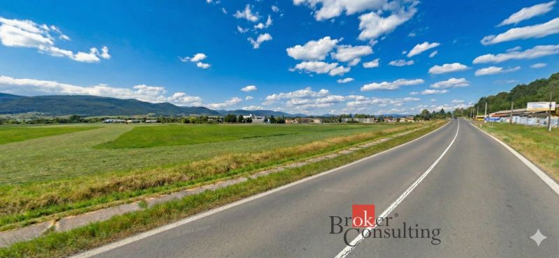 Hliník nad Hronom, Grundstücke - Gewerbe, grüne Wiesen an einer von Hügeln und Gebäuden umgebenen Straße.
