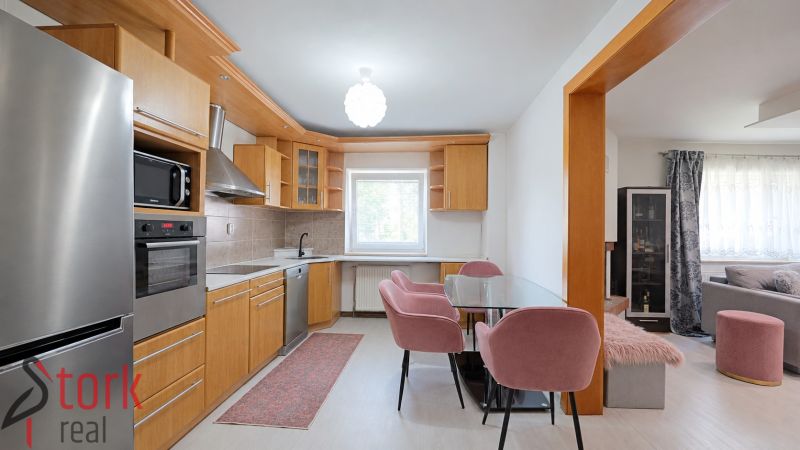 Küche mit Holzdekor und rosa Stühlen in einem Einfamilienhaus.