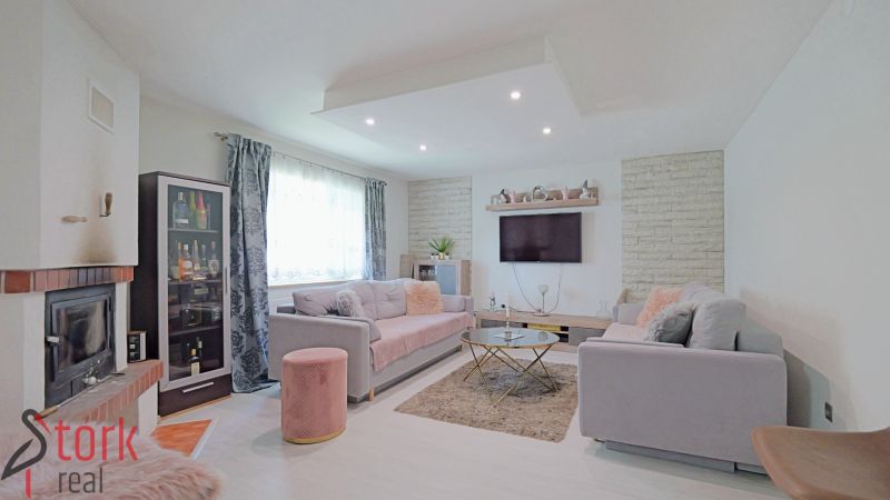 Wohnzimmer in einem Einfamilienhaus mit Kamin, Sofas, Glasvitrine und Sofas.