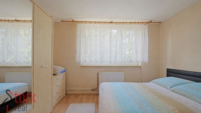 Ein Schlafzimmer mit einem Bett, einem Schrank und einem Holzboden in einem Einfamilienhaus.