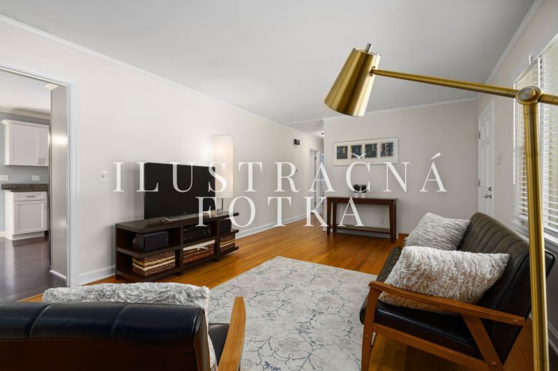 Wohnzimmer in einer 3-Zimmer-Wohnung, mit Sofa und Fernseher, Boden mit Holzdekor.