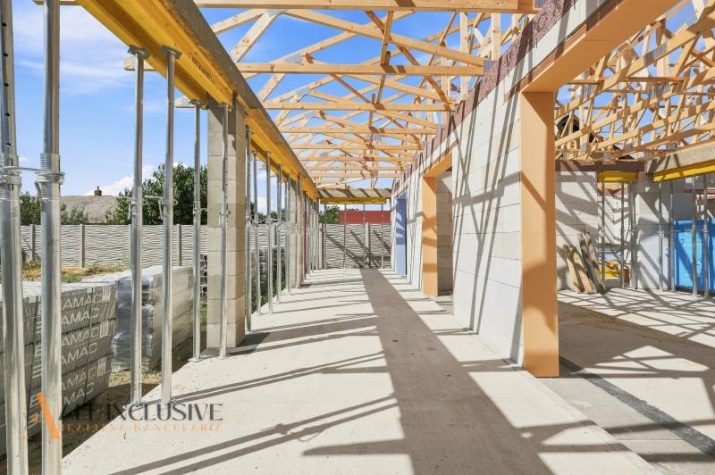 Ein im Bau befindliches Einfamilienhaus in Marcelová mit freiliegenden Dachkonstruktionen und Stützpfeilern.