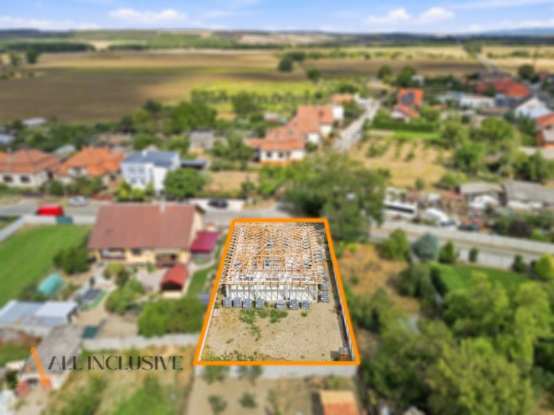 Ein im Bau befindliches Einfamilienhaus in Marcelová, umgeben von Gärten und Natur.