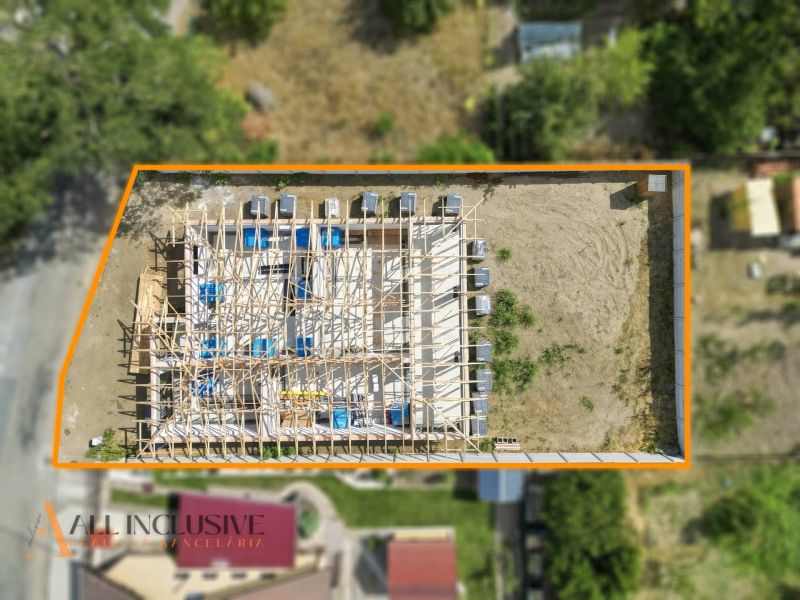 Der Bau eines Einfamilienhauses in Marcelová von oben, umgeben von einem orangefarbenen Rahmen, umgeben von Grün.