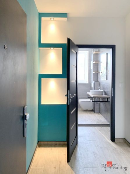 Innenraum einer 1-Zimmer-Wohnung mit Holzboden und modernem Badezimmer.