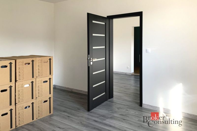 Einzimmerwohnung mit Holzboden und Kartons im Raum.