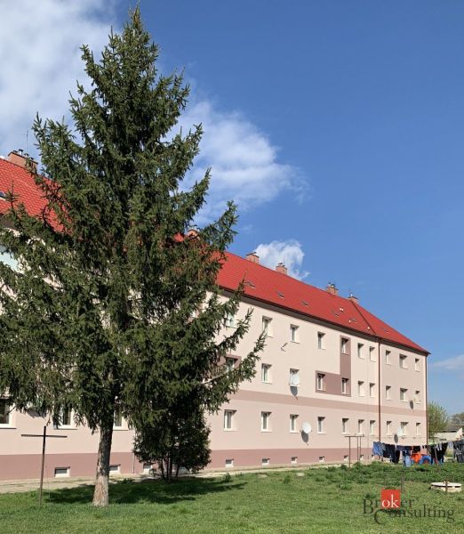 Das Gebäude mit roten Dächern und einem Baum davor, in der Železničná-Straße in Šahy.
